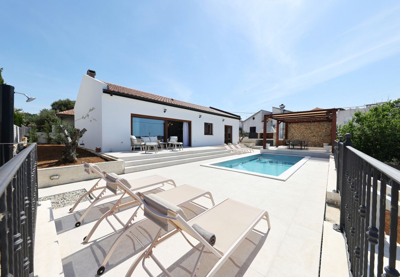 Sun terrace of Villa Diaria with private pool, sun loungers and exterior view in Vrsi