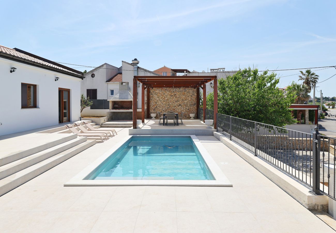 Pool terrace of Villa Diaria with private pool, sun loungers, pergola and barbecue area in Vrsi