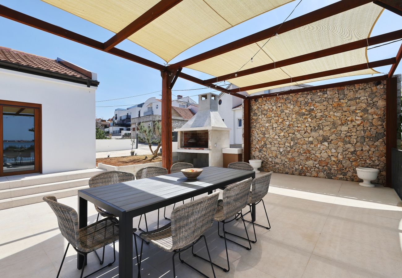 Covered outdoor dining area on the terrace of Villa Diaria with pergola and barbecue in Vrsi