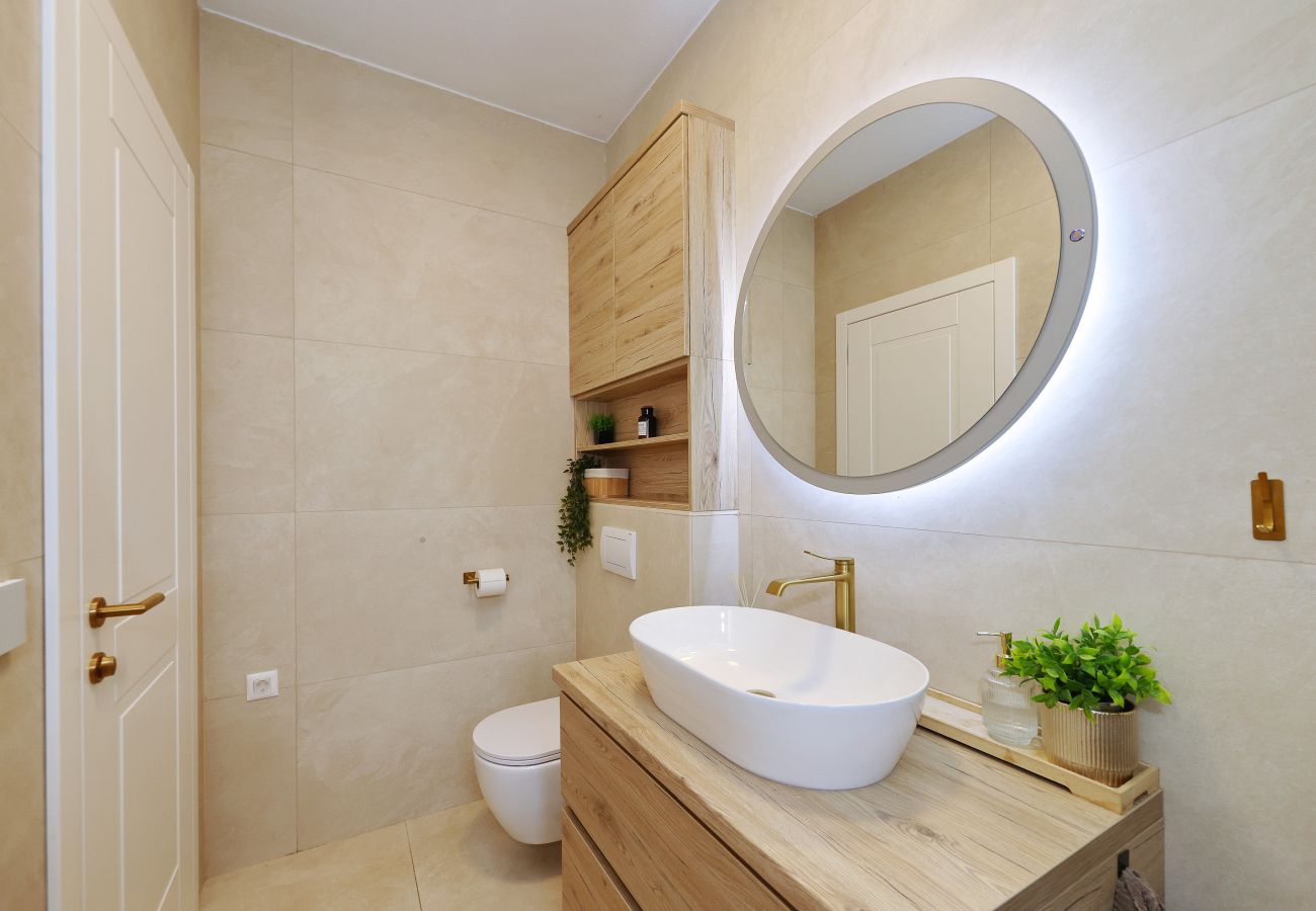 Bright bathroom of Villa Diaria with washbasin, round mirror and toilet in Vrsi