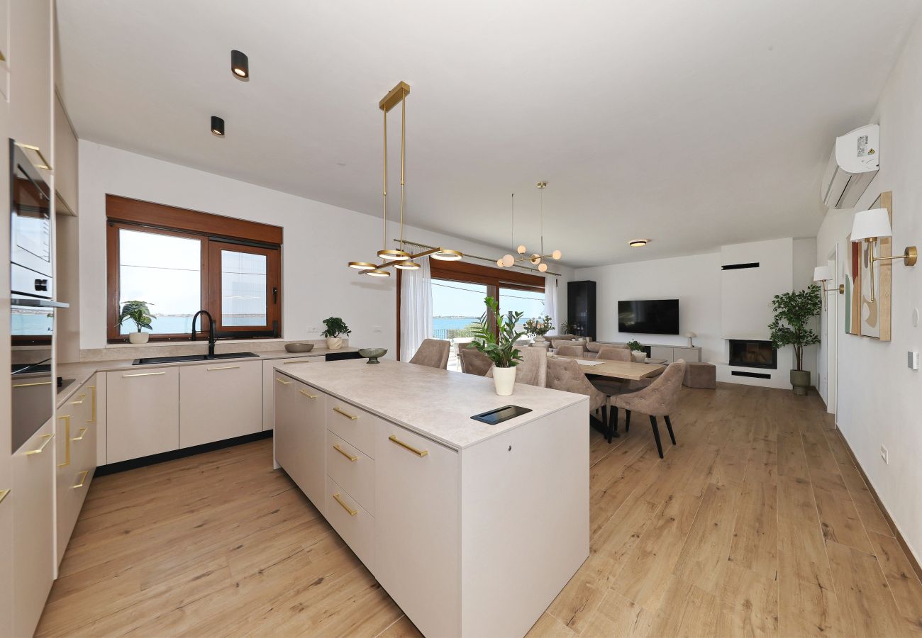 Open kitchen of Villa Diaria with kitchen island, dining area and modern living area in Vrsi