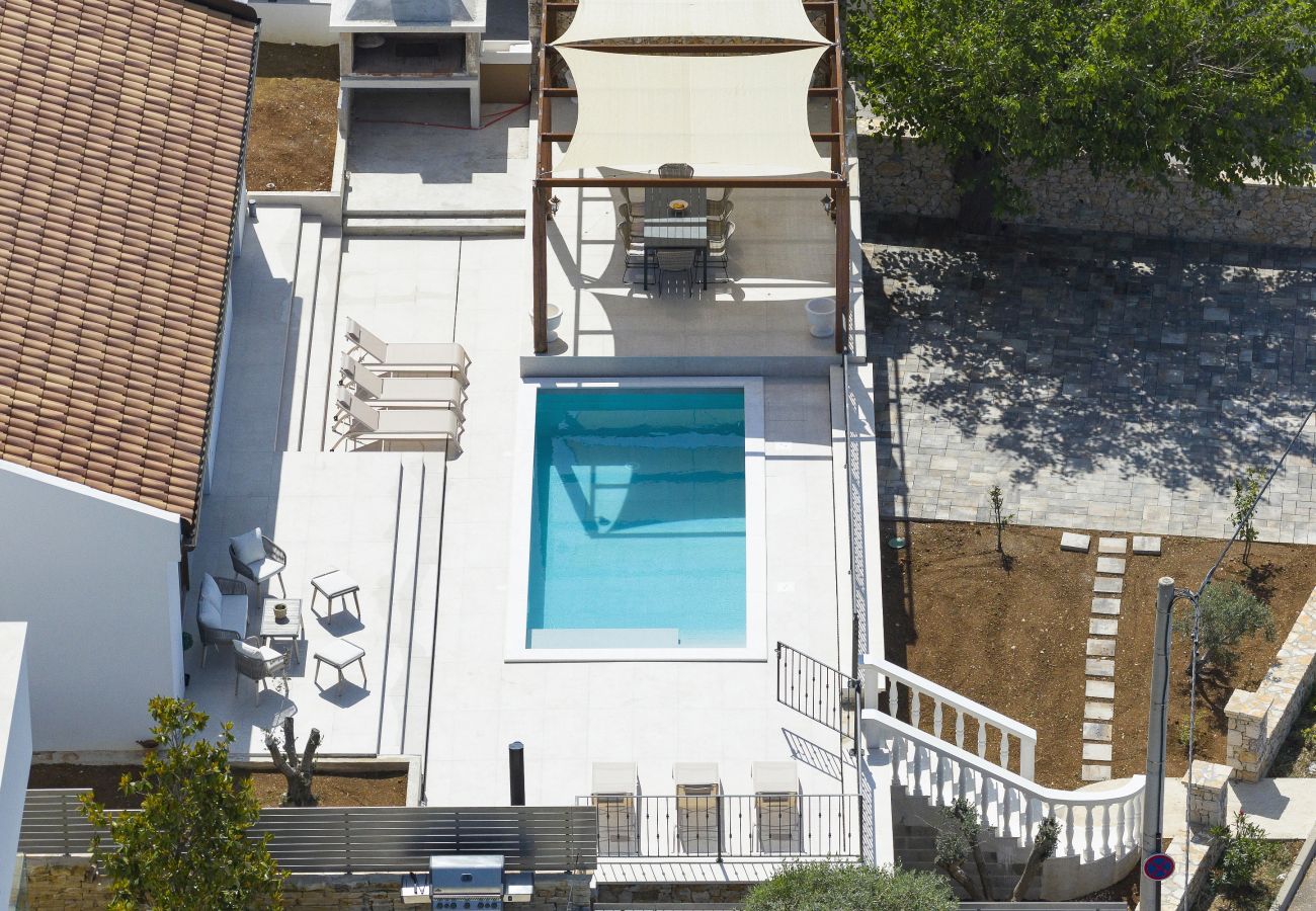 Aerial view of the terrace of Villa Diaria with private pool, sun loungers and pergola in Vrsi