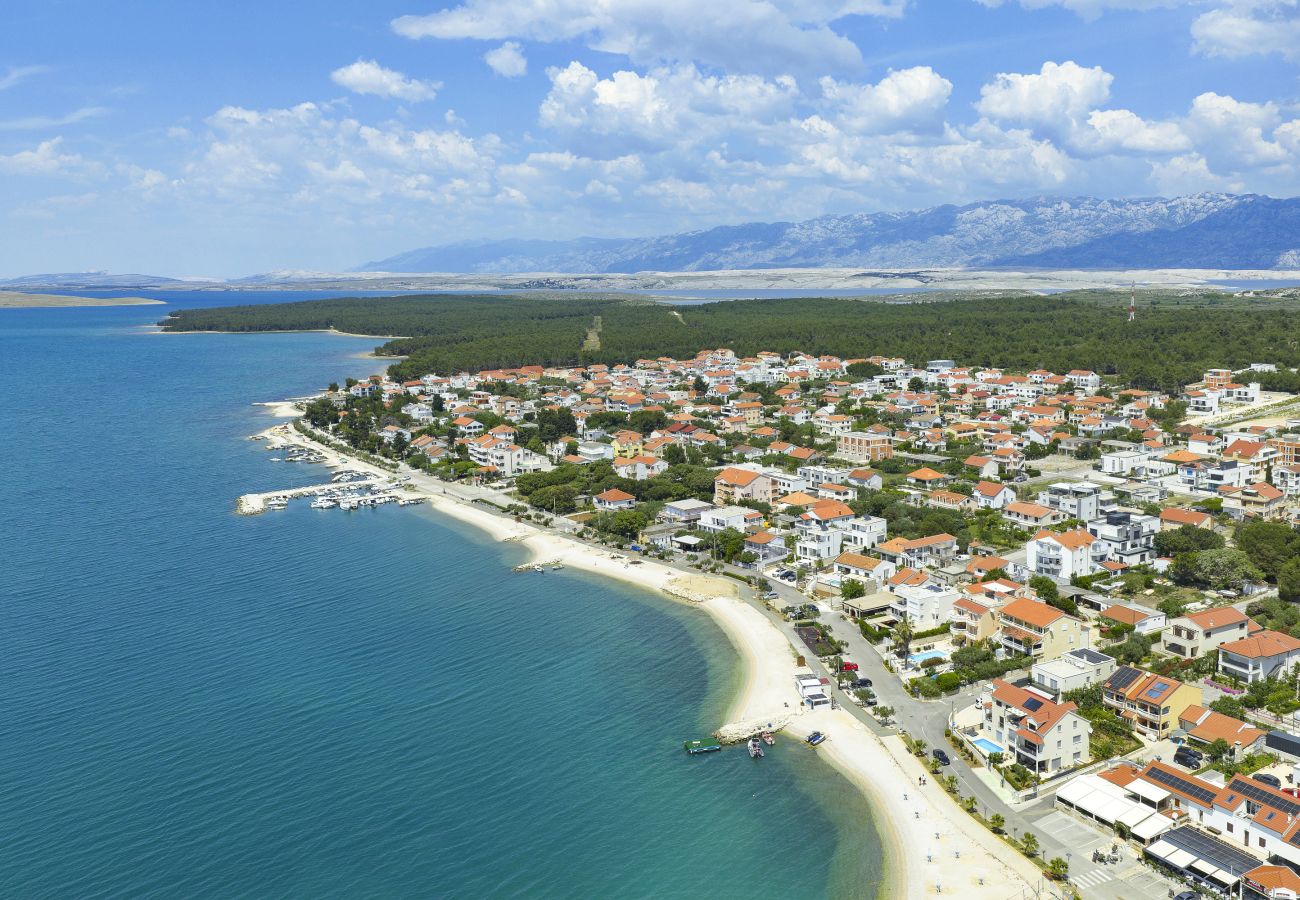 Drone view of Vrsi with beach, clear sea, village setting and Velebit mountains
