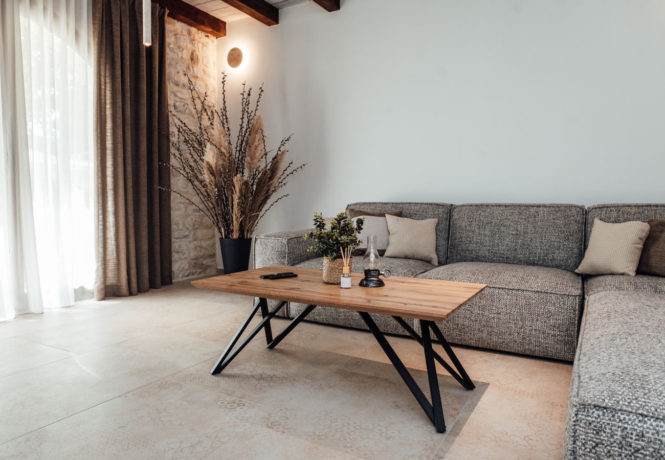 Bright living area of Gland Residence in Nin with seating area, coffee table and stone details.