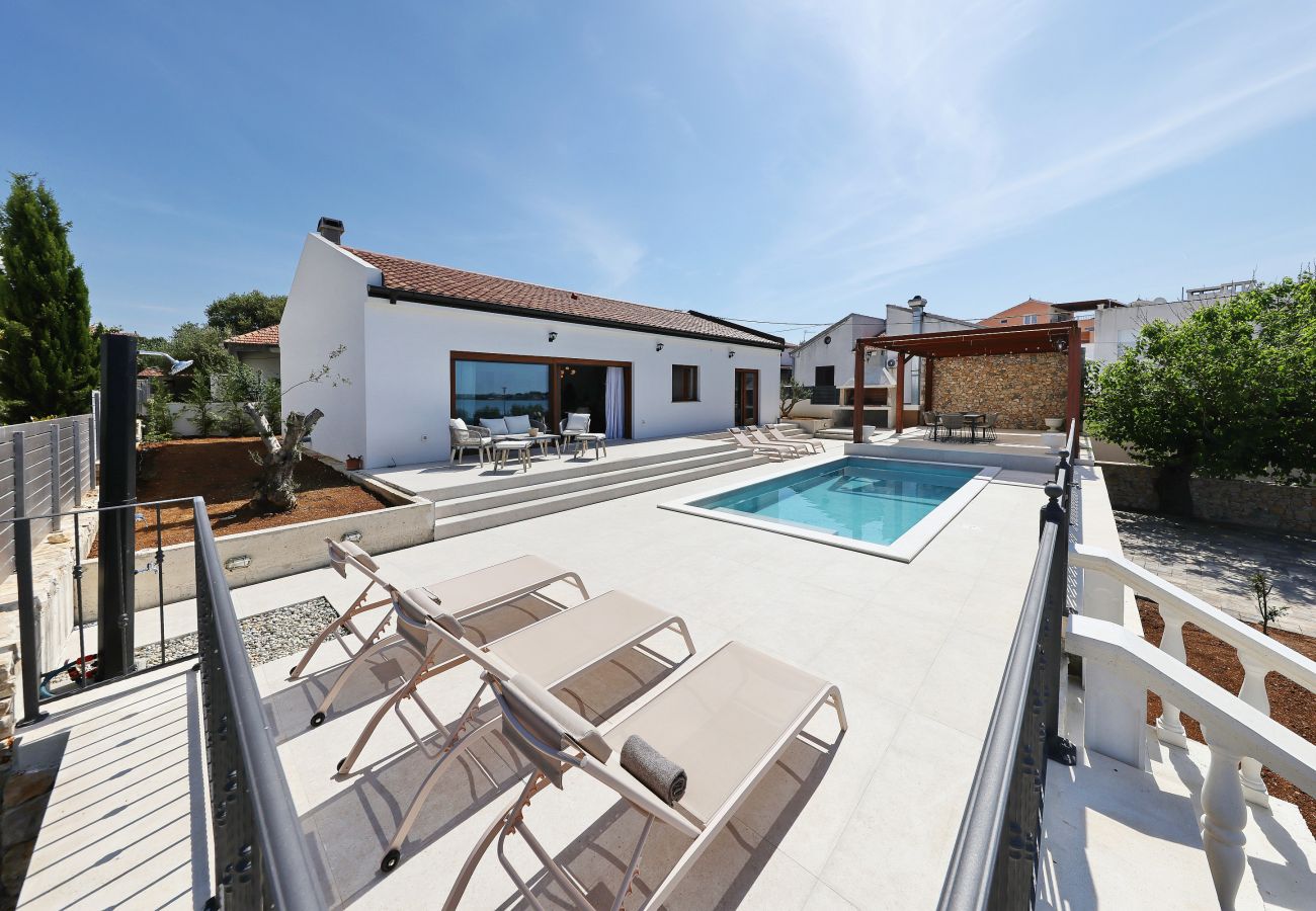 Große Terrasse der Villa Diaria mit privatem Pool, Sonnenliegen und moderner Hausansicht in Vrsi