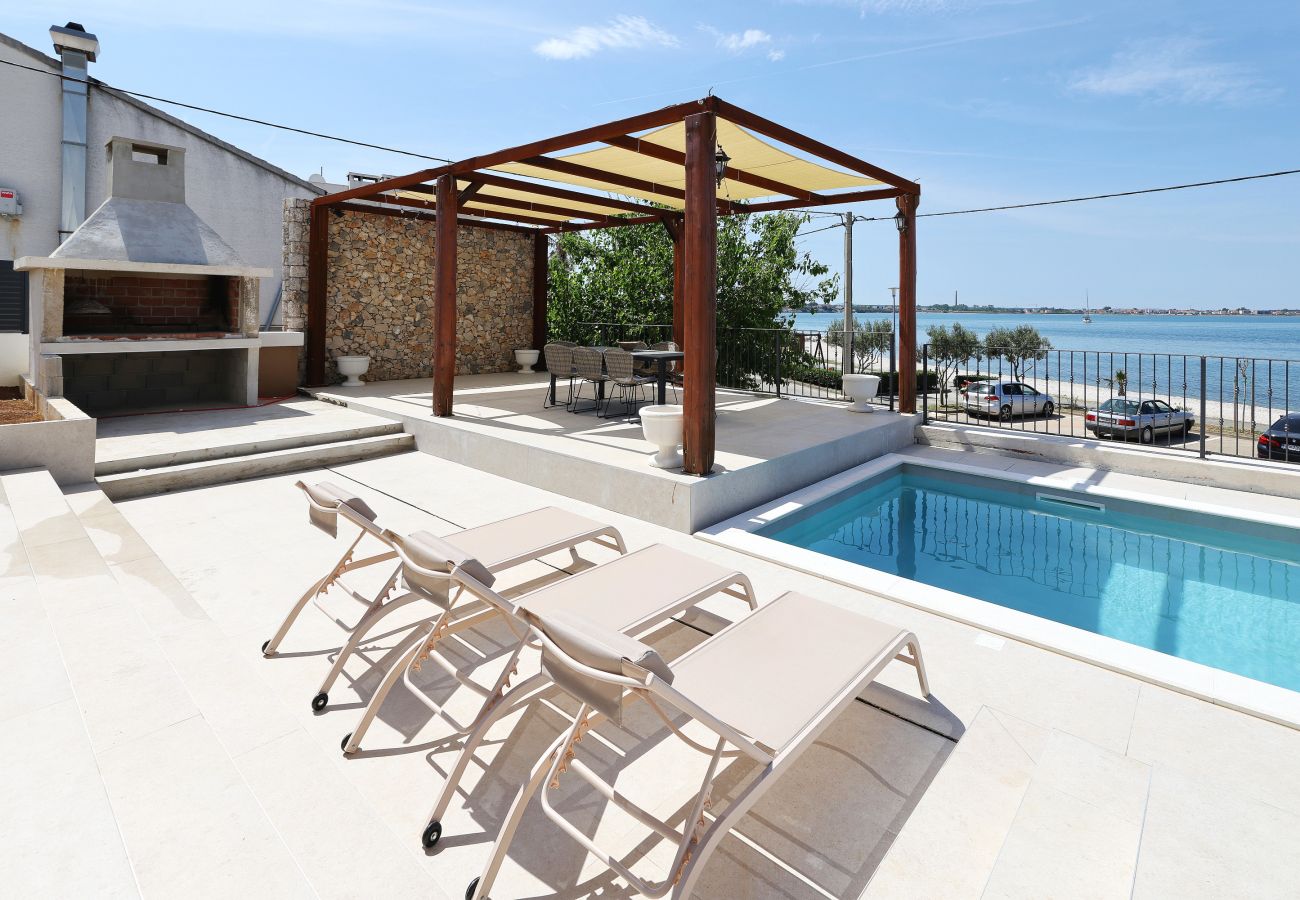 Terrasse der Villa Diaria mit privatem Pool, Sonnenliegen, Pergola und Grill in Vrsi