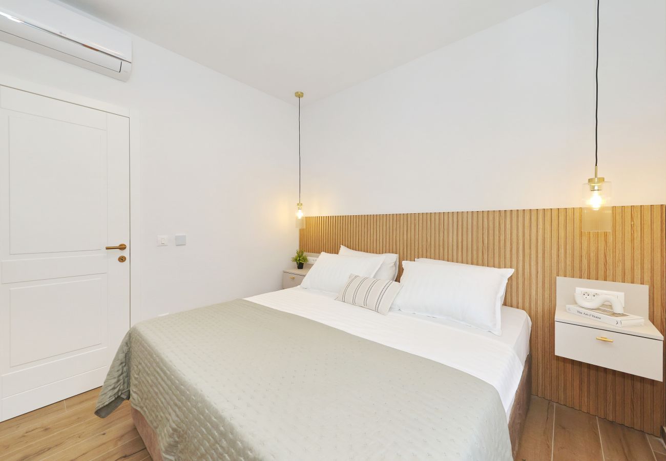 Helles Schlafzimmer der Villa Diaria mit Kingsize-Bett, Nachttisch und Klimaanlage in Vrsi