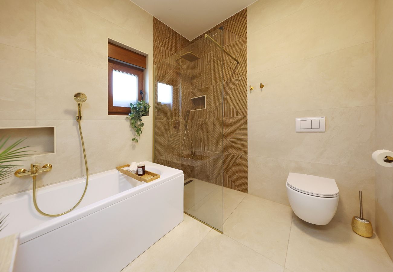 Badezimmer der Villa Diaria mit Badewanne, bodengleicher Dusche und WC in Vrsi