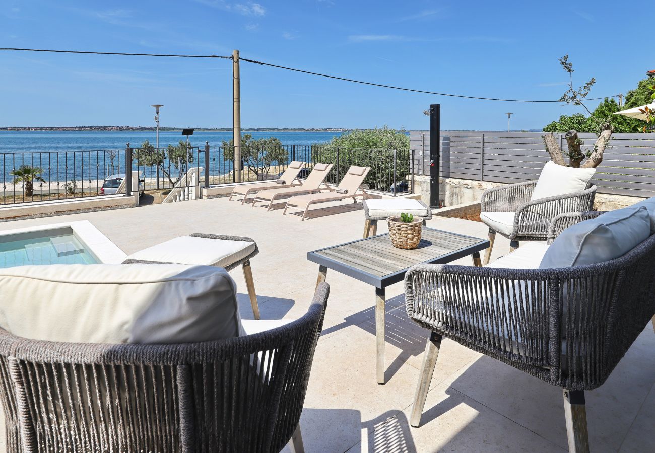 Terrassenlounge der Villa Diaria mit Poolbereich, Sonnenliegen und Meerblick in Vrsi