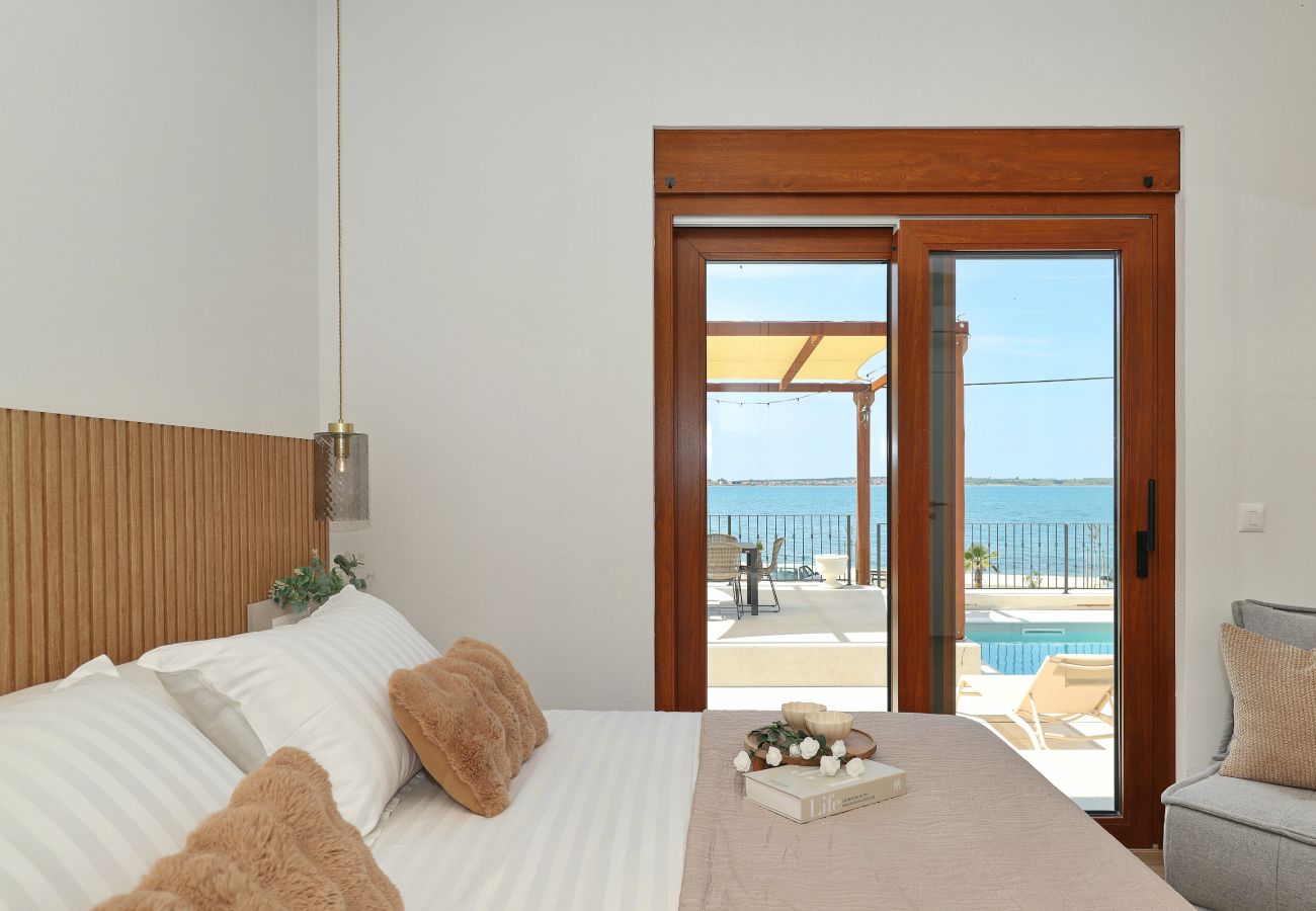 Schlafzimmer der Villa Diaria mit Terrassenzugang, Poolblick und Meerblick in Vrsi