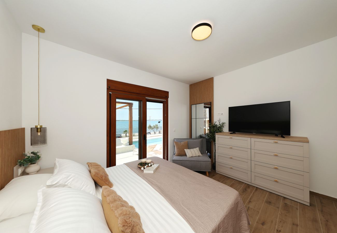 Schlafzimmer der Villa Diaria mit Kingsize-Bett, Smart-TV, Sitzbereich und Terrassenzugang in Vrsi
