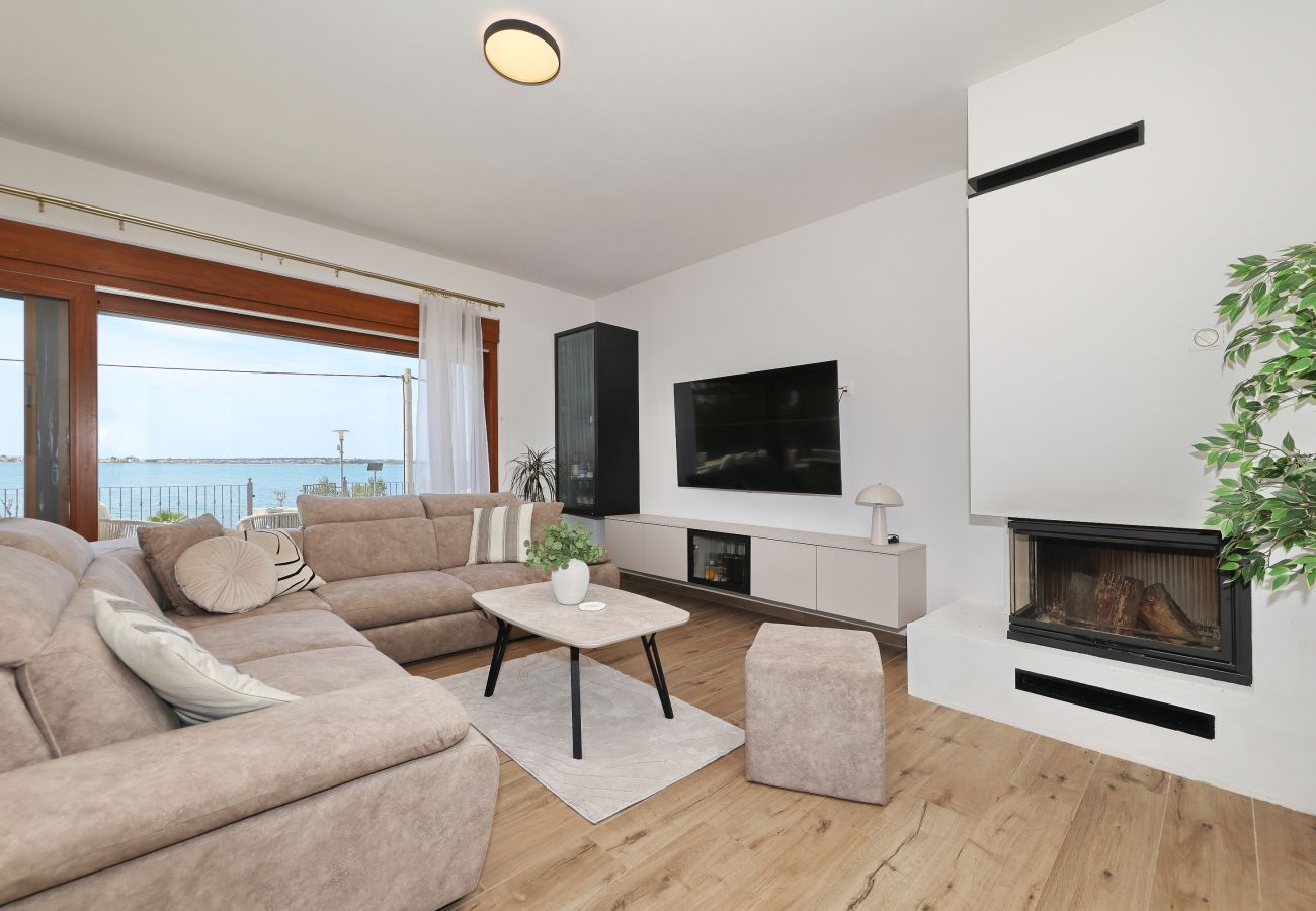 Wohnbereich der Villa Diaria mit Couch, Smart-TV, Kamin und Meerblick in Vrsi