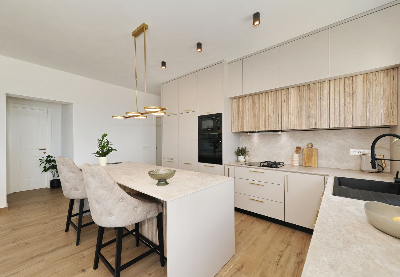 Moderne Küche der Villa Diaria mit Kücheninsel, Sitzplätzen und Einbaugeräten in Vrsi