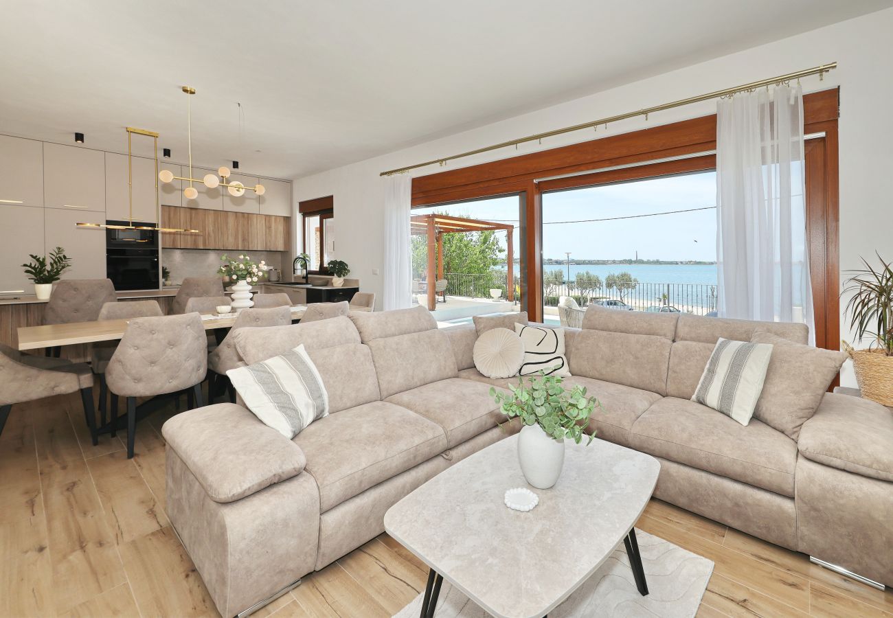 Offener Wohnbereich der Villa Diaria mit Couch, Essplatz, Küche und Meerblick in Vrsi