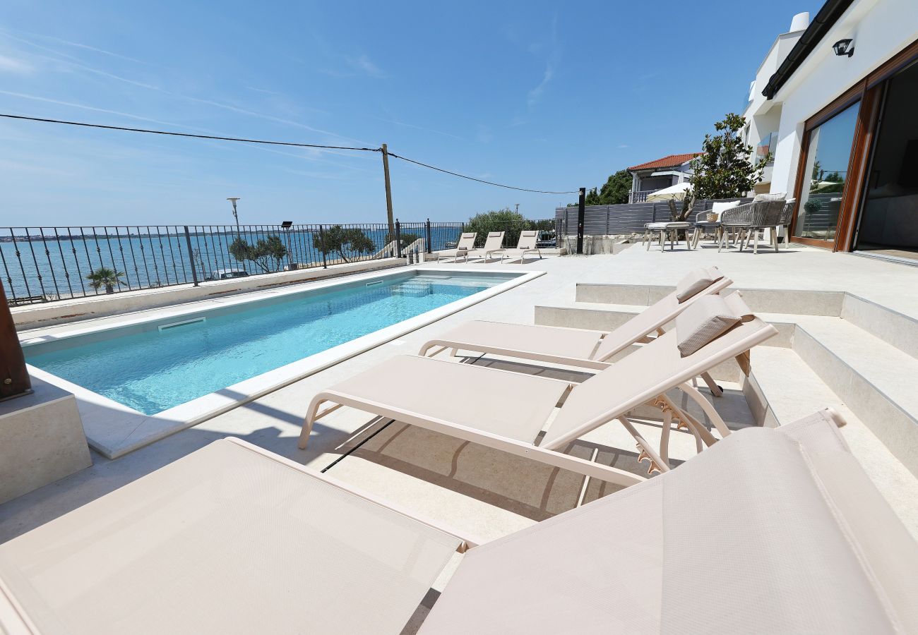 Sonnenterrasse der Villa Diaria mit Sonnenliegen, privatem Pool und Meerblick in Vrsi