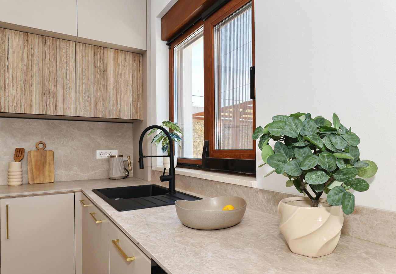 Küchendetail der Villa Diaria mit Spüle, Arbeitsfläche und Fenster in Vrsi