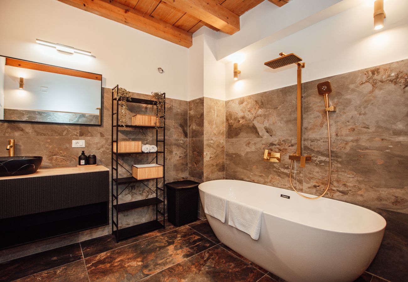 Badezimmer im Erdgeschoss der Gland Residence in Nin mit Regendusche, Badewanne, Waschtisch und moderner Ausstattung.