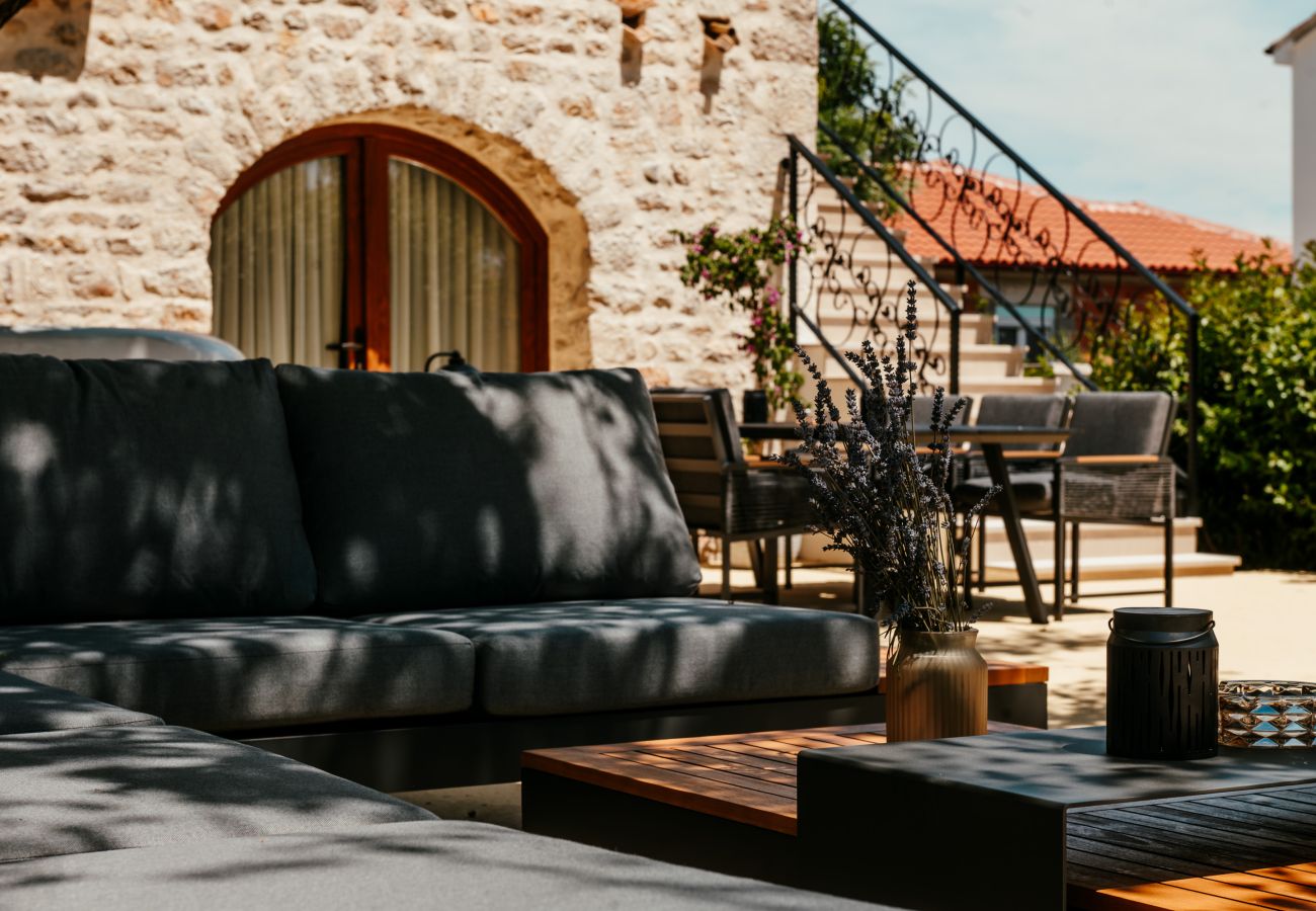 Terrasse der Gland Residence in Nin mit Lounge, Essplatz im Freien und Natursteinfassade.
